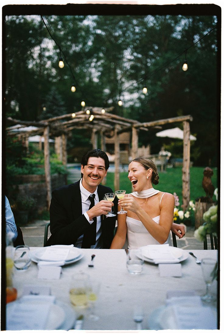 A bride and groom toasting champagne at their outdoor wedding reception